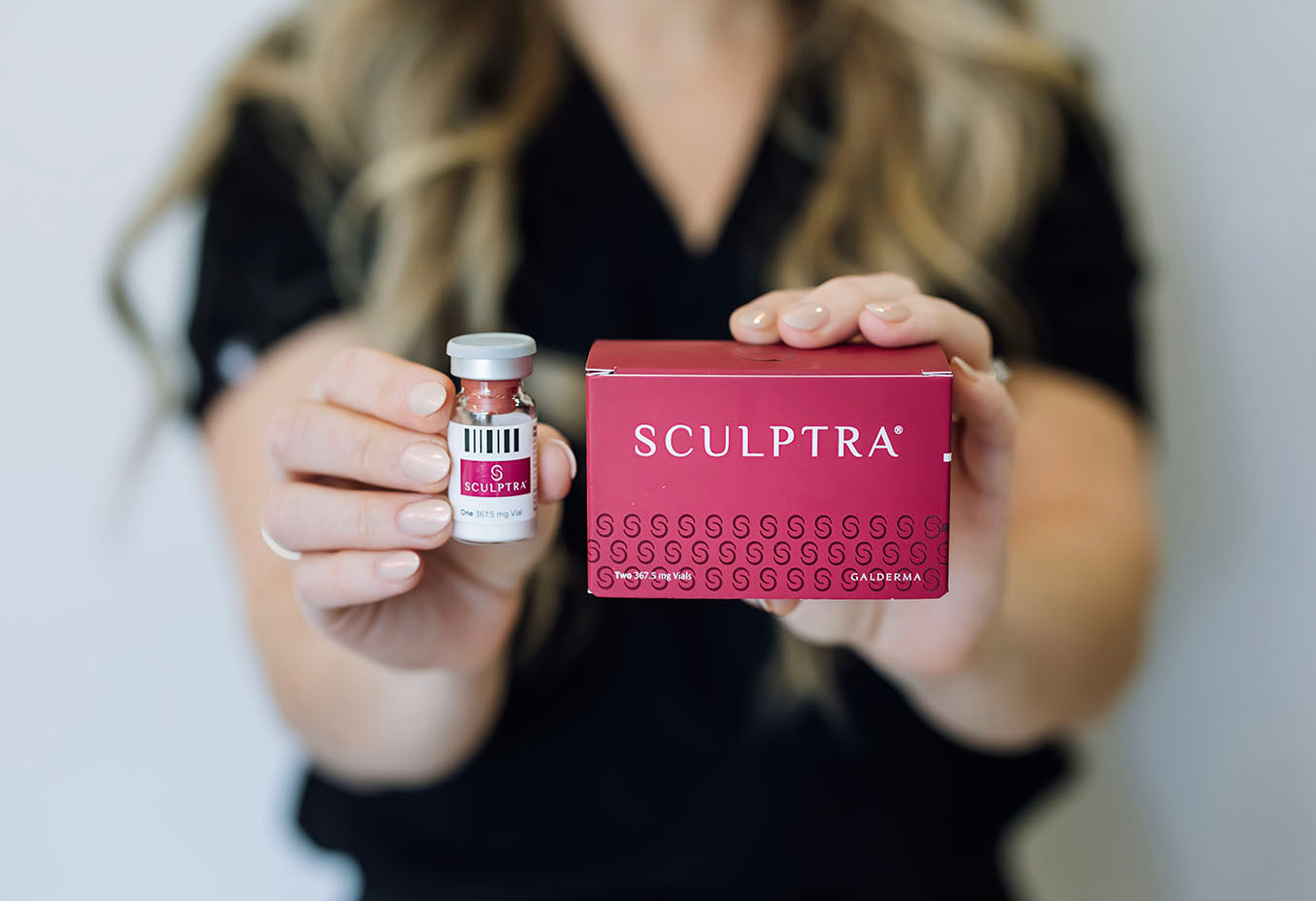 woman holding Sculptra injectables vial and box at Skin Design Aesthetics in South Shore, MA