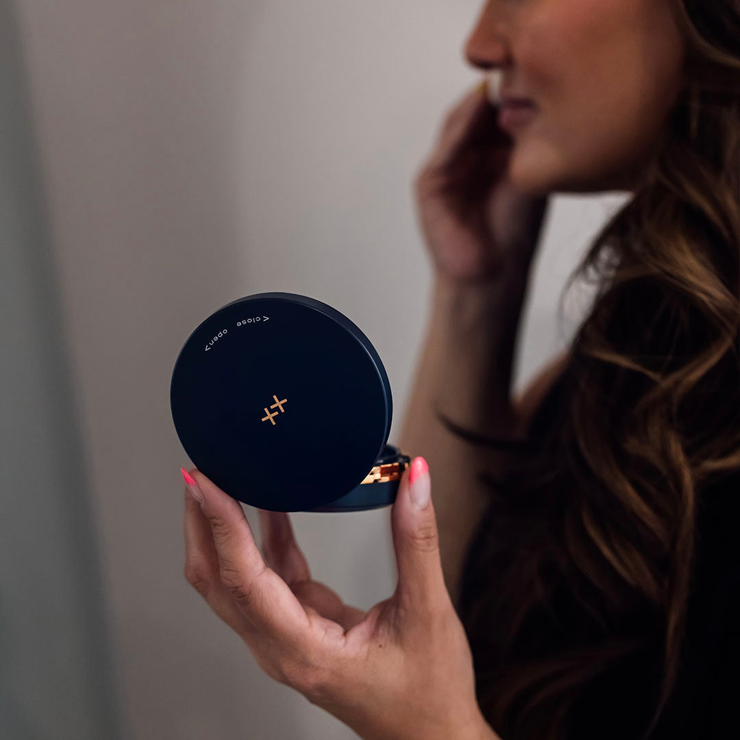 woman holding skinbetter science sunbetter tonesmart spf compact and applying it to her face